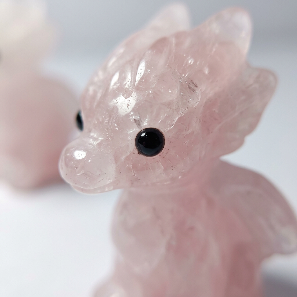 Extreme macro detail of carved rose quartz baby dragon face and wings