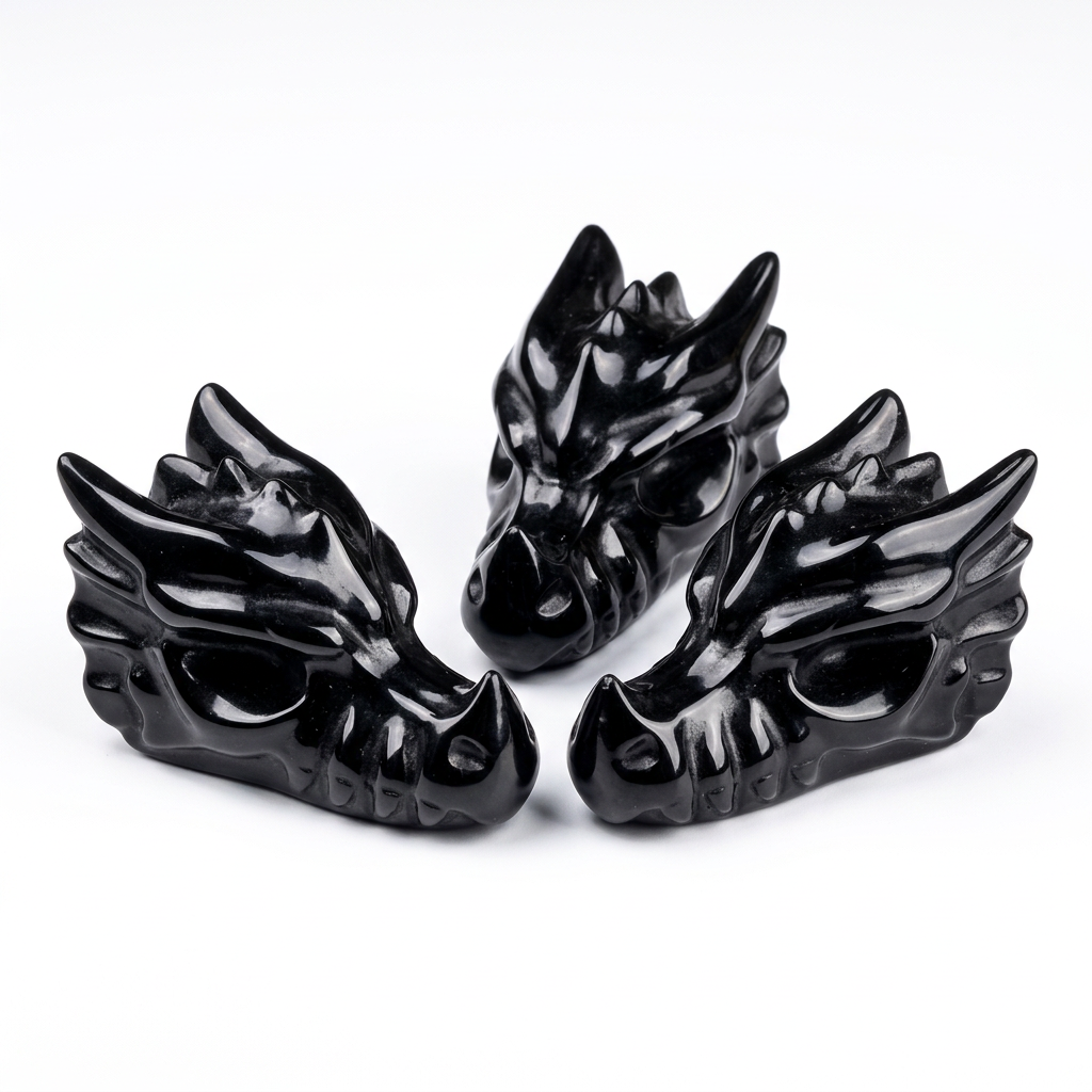 Three Natural Black Obsidian Dragon Head Carvings on pure white background